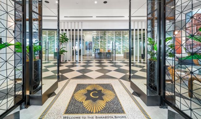 an entrance with mirrors on the wall and custom stone work on the floor