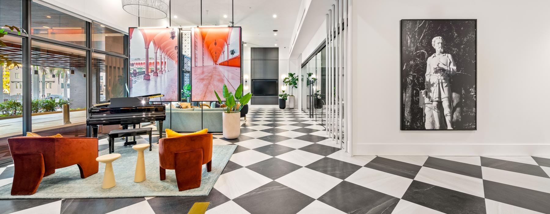 a room with a art a black and white checkered floor and seating